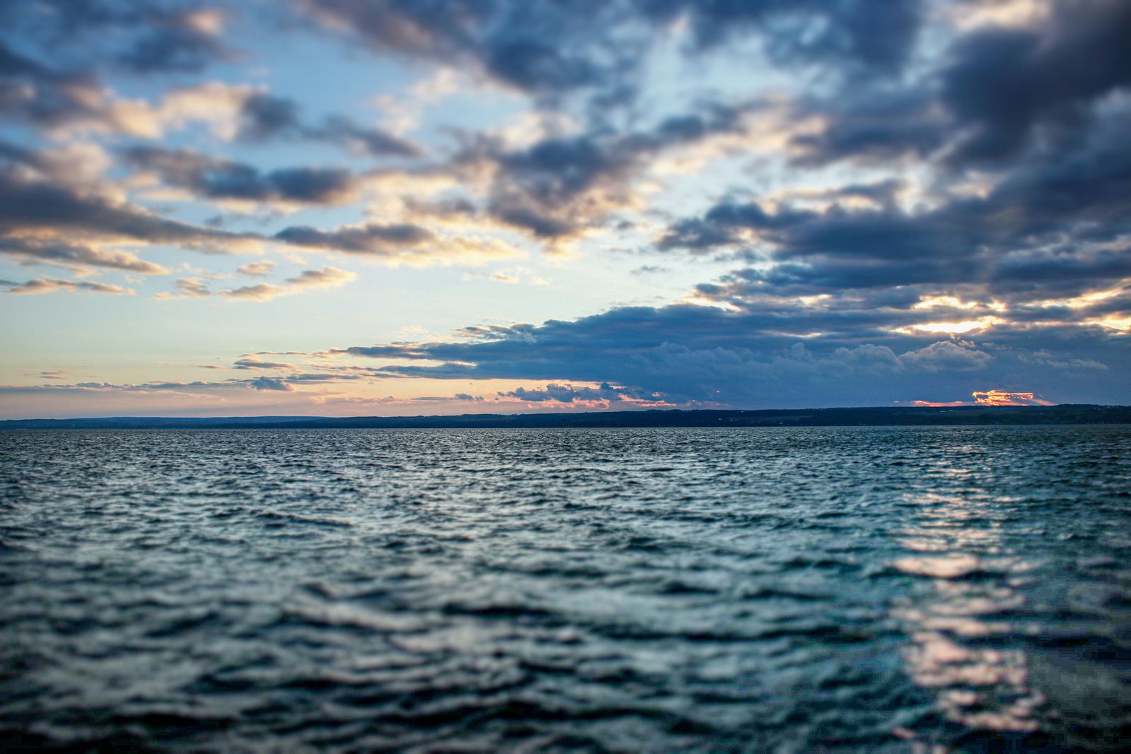 Dusk over a wide lake, clouds lit by the setting sun